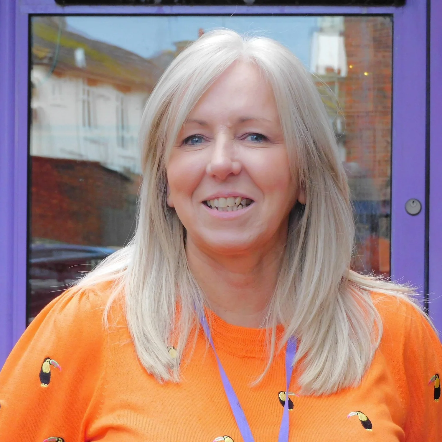 New CEO Mel Goddard, wearing an orange shirt, she has blonde hair and is smiling